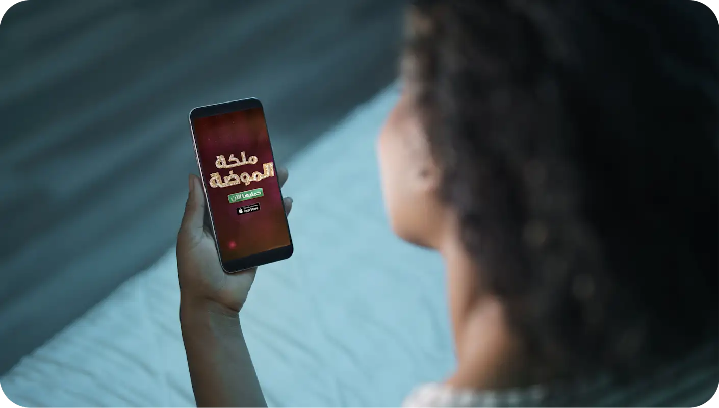 امرأة تستمتع بلعبة على هاتفها المحمول