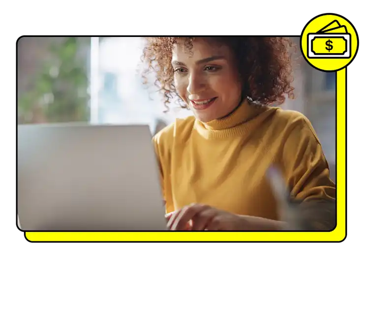 A Snapchat advertiser types on laptop with money icon in yellow above the photo