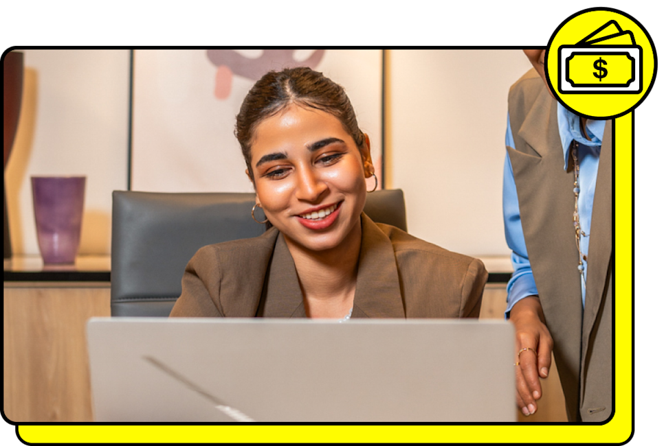 A Snapchat advertiser types on laptop with money icon in yellow above the photo