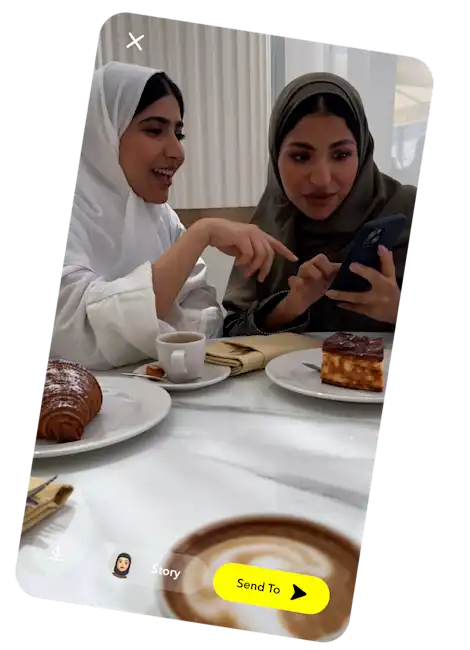 Two girls on their phone using Snapchat. 