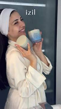 Creator smiling while holding Izil body mask products highlighting brand awareness through Snapchat advertising.