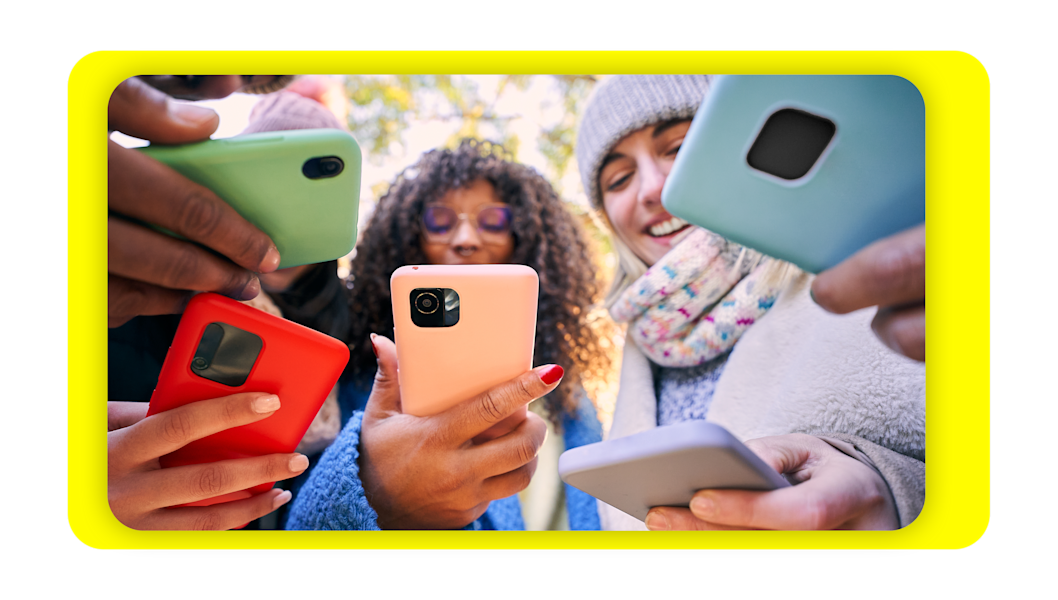 Group of young people looking at their cell phones.