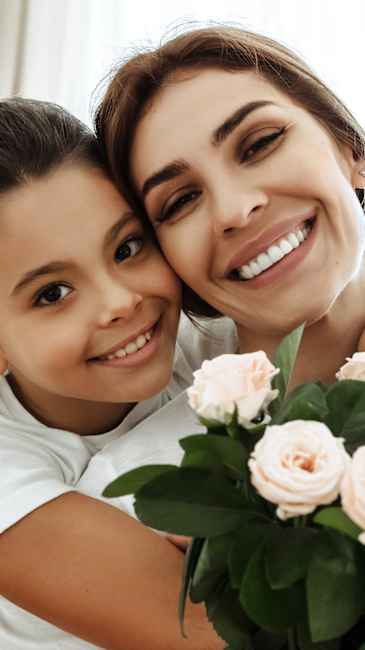 Mother and daughter posing with roses.