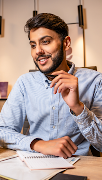 محترف اعمال يراجع خططا على مكتب، يوضح كيف تتماشى اهداف اعلانات سناب شات مع اهداف الاعمال المختلفة.