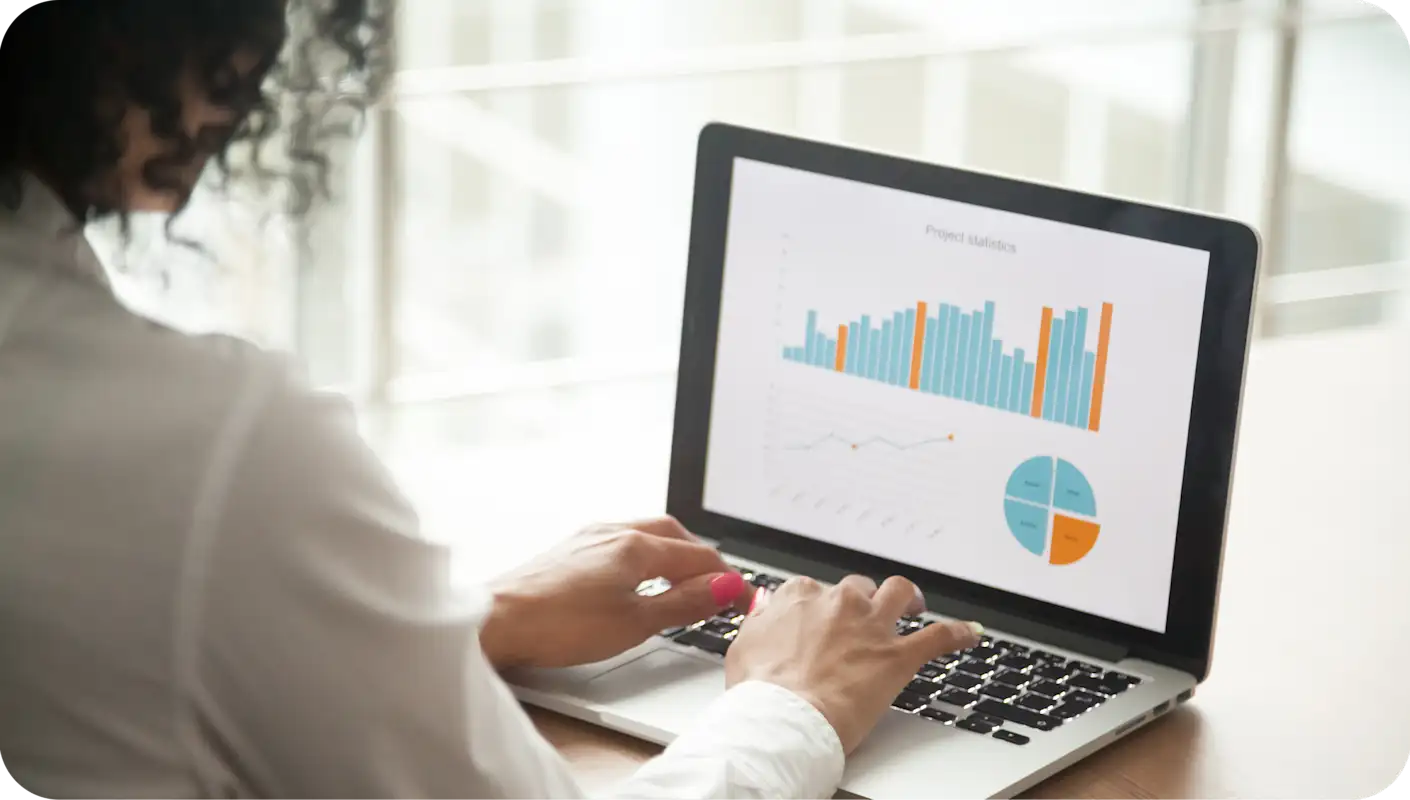 Woman interacting with a couple charts on her laptop