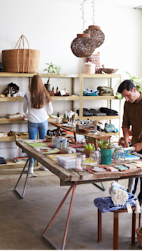 A woman and a man working in their clothing and household goods shop