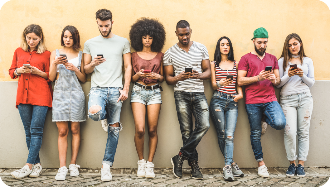 Five young women and three young men against a wall, each interacting with their mobile phone