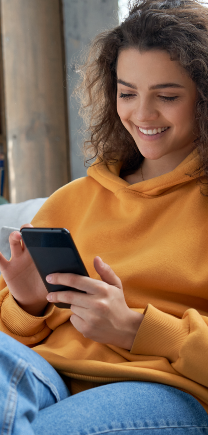 Woman smiling while tapping on her mobile phone