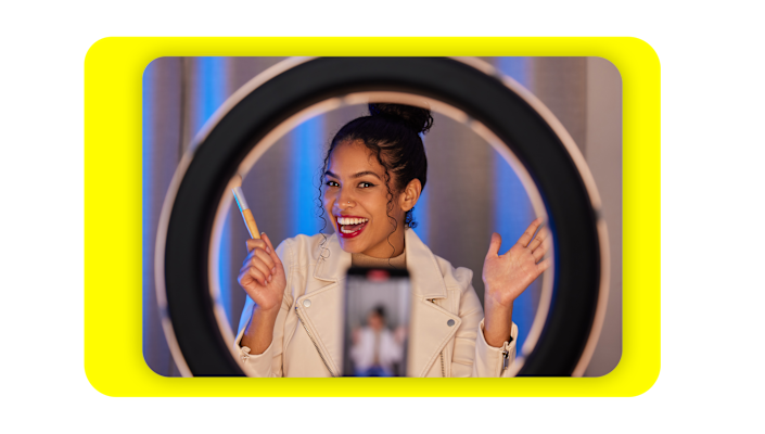 Image of a woman using a selfie light to record a video