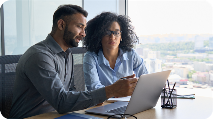 2 people working on a laptop