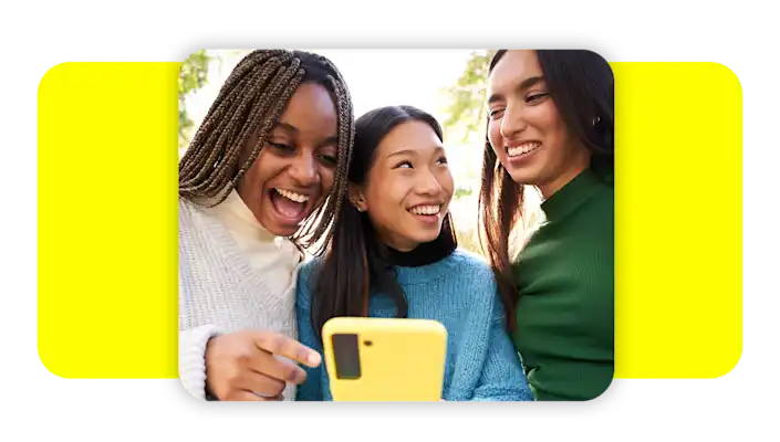 Group of friends laughing at something on their cell phone.