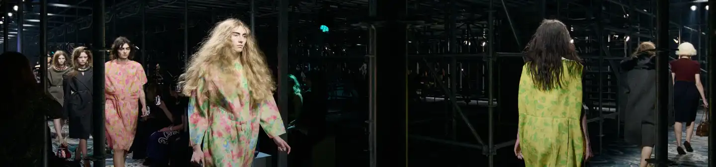 Behind the scenes at Prada Womenswear Fall/Winter 2025: Models turn a corner in vibrant ready-to-wear designs.