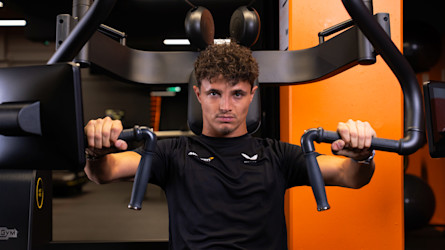 Lando Norris, a McLaren F1 pilótája, egy Technogym Biostrength Chest Press-en edz a McLaren Performance Hub-jában.