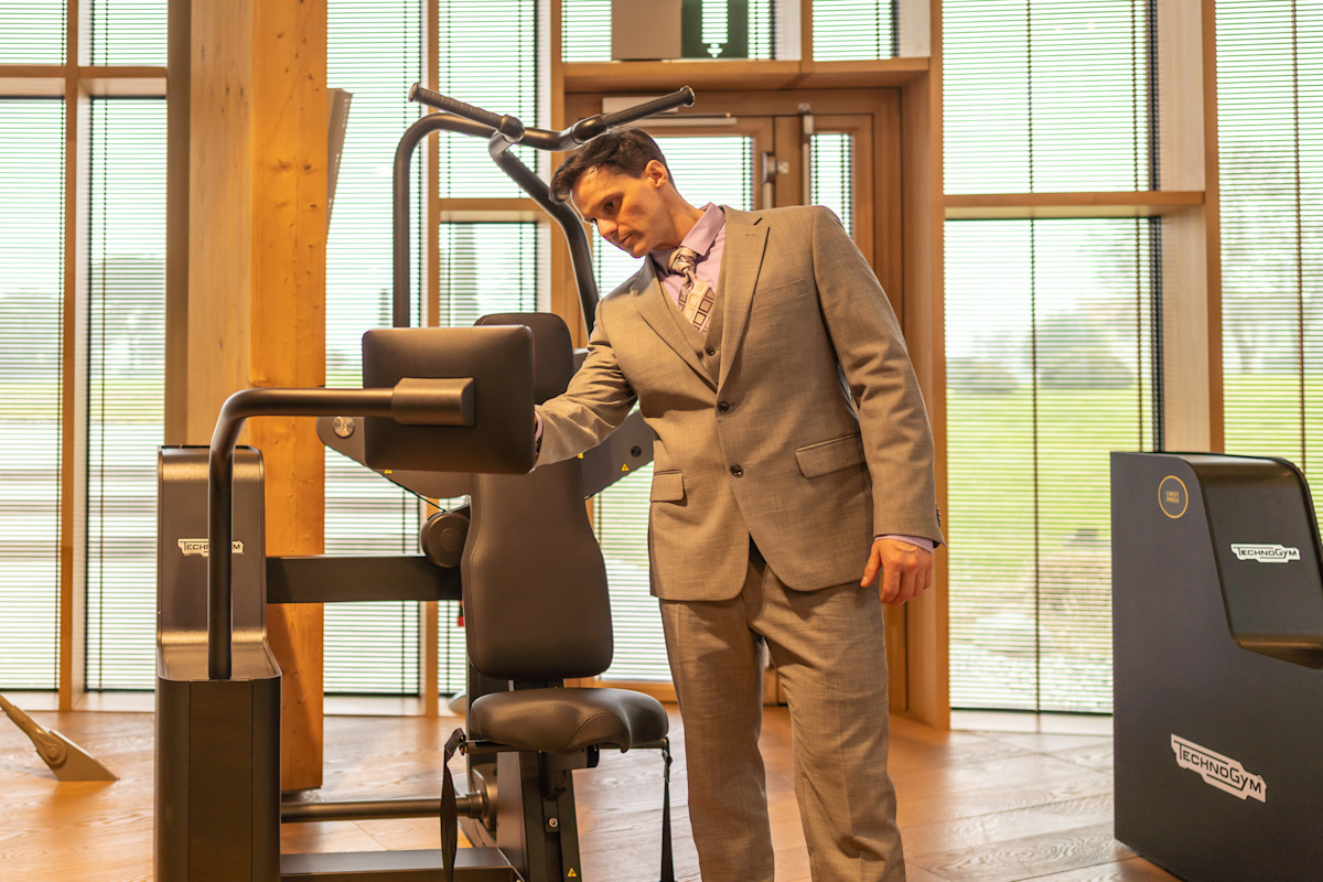 Dr Kampert setting up resistance parameters on a Technogym Biostrength Vertical Traction machine