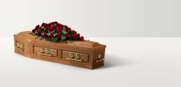 Pannelled oak coffin with rose floral arrangement on top