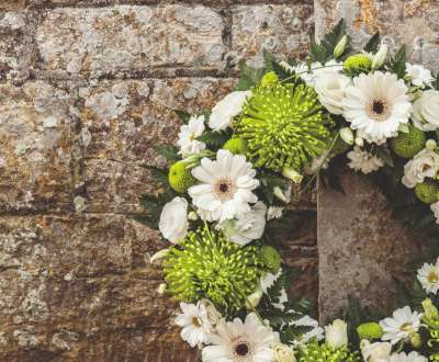 Wreath with white flowers on a stone wall