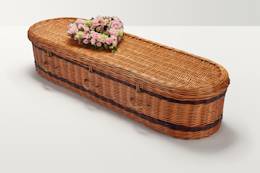 Zoomed out shot of pastel pink floral display on top of coffin