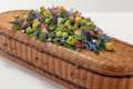 Brightly coloured country mixed coffin spray on top of coffin
