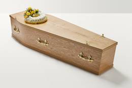 Zoomed out shot of yellow wreath of flowers on top of coffin