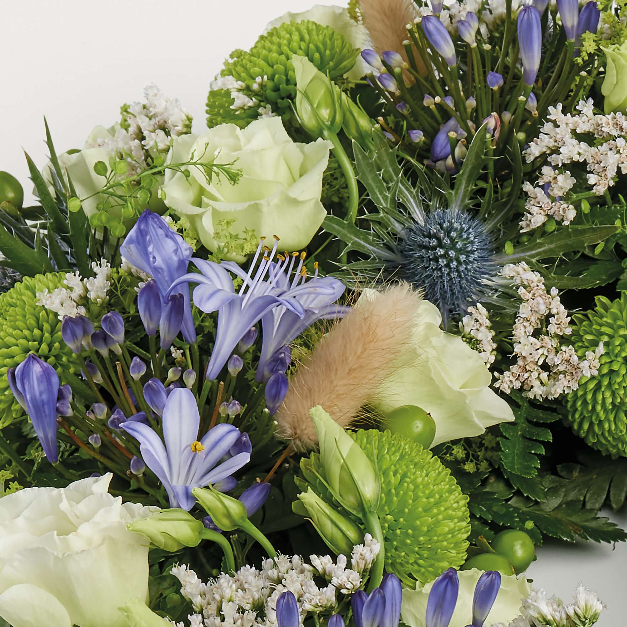 Zoomed in shot of blue and green wreath of flowers 
