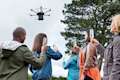 A drone flying above a family who are raising glasses in a toast