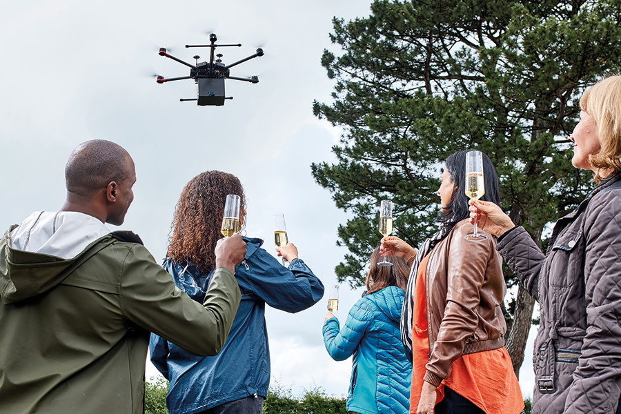 A drone flying above a family who are raising glasses in a toast