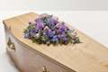 A combination of purple flowers on top of coffin 