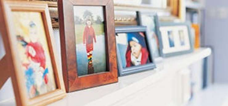 Picture frames containing family members on a fireplace  