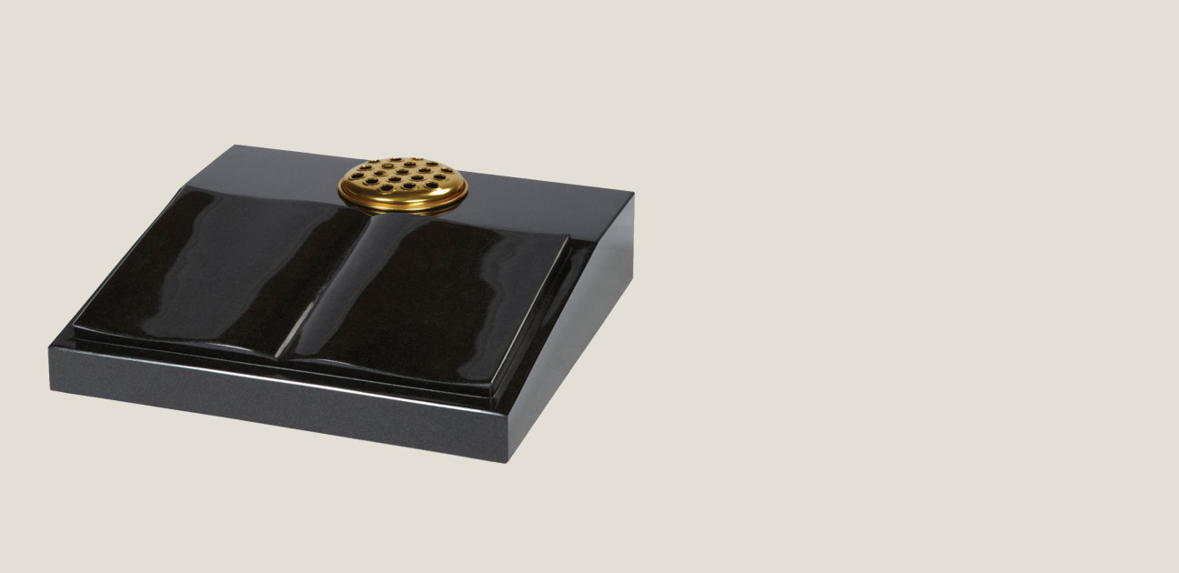 Black stone memorial of a book with a flower holder