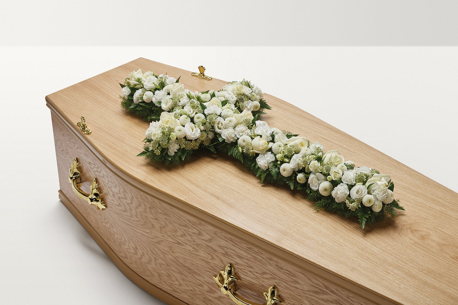 White flowers in the shape of a cross on coffin