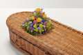 Brightly coloured rounded flower display on top of coffin