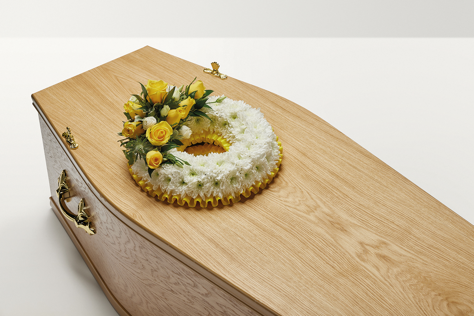 Yellow wreath of flowers on coffin