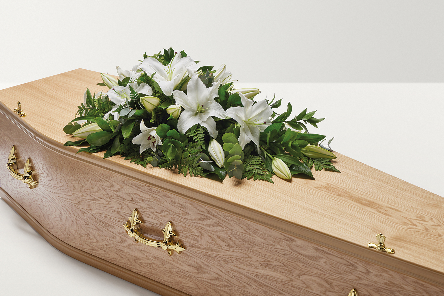 White lily flowers on top of coffin 