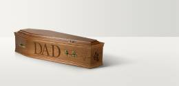 Full length image of a wooden coffin with brass coloured handles and 'Dad' engraved on the side