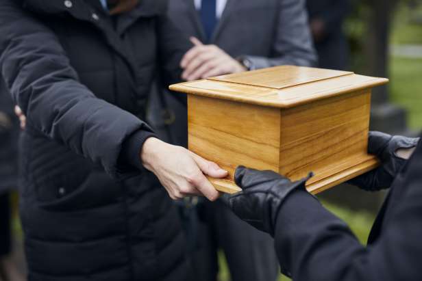 A traditional casket being carried at a funeral