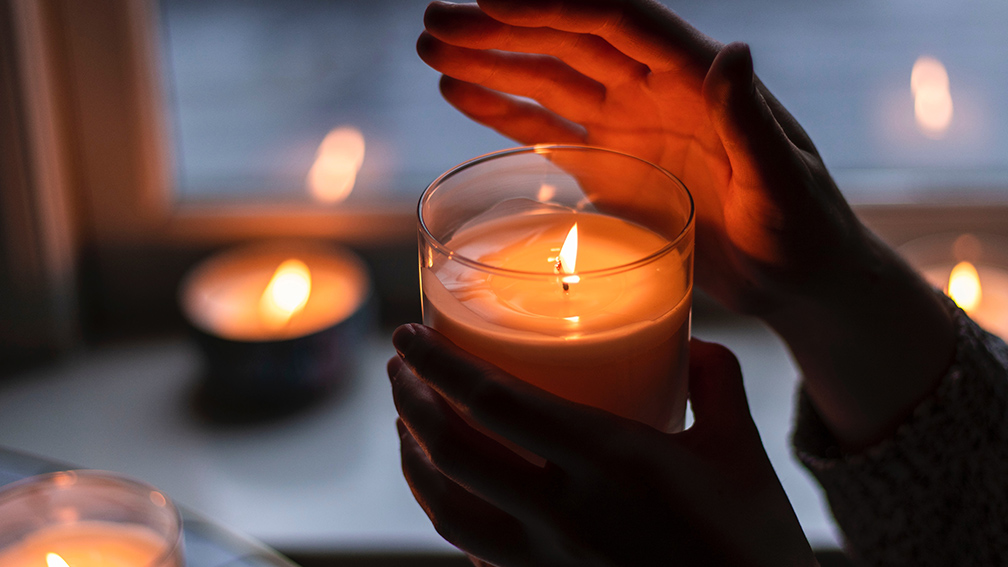 A woman holding a lit candle.