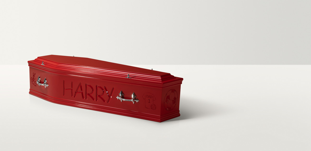 Full length image of a red coffin with silver handles and 'Harry' engraved on the side