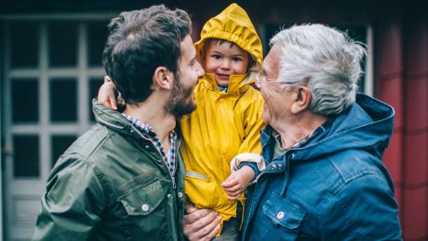 Dad, son and grandchild out in their rain coats.