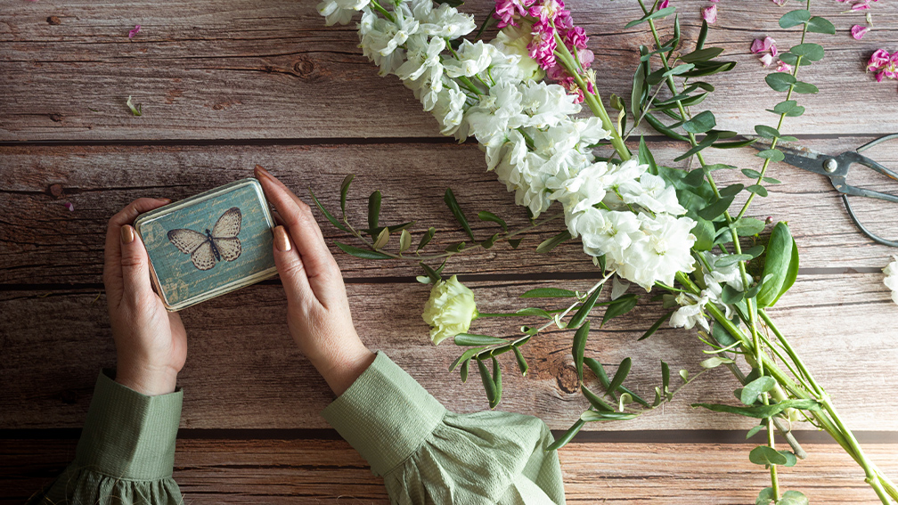 A wooden table with flowers and butterfly gift