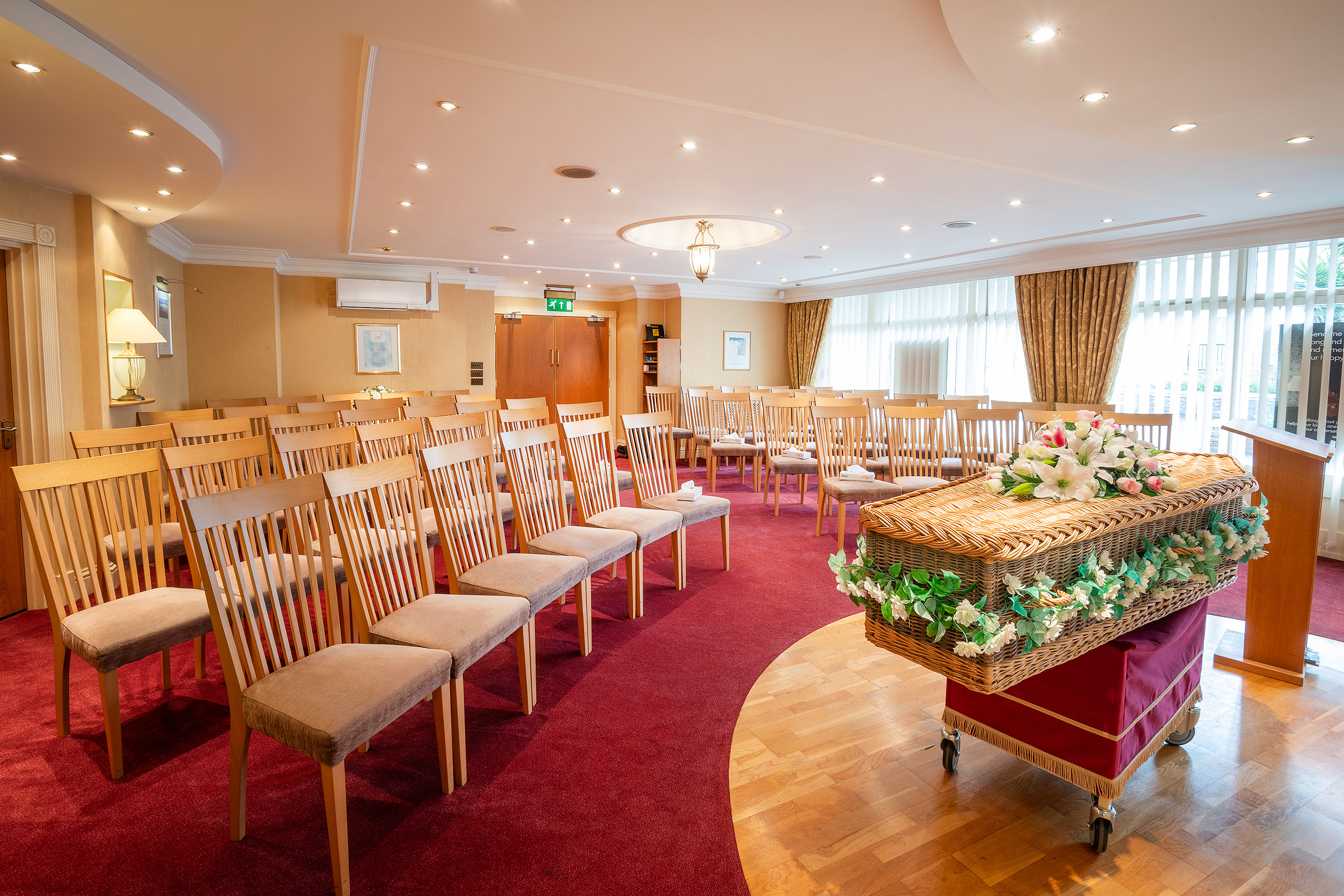 Coffin at the front a room with chairs