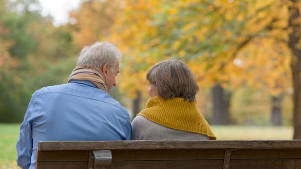 Couple sitting on a bench in a park. 
