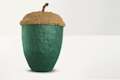 Textured acorn shaped urn. The bottom part of the urn is dark green