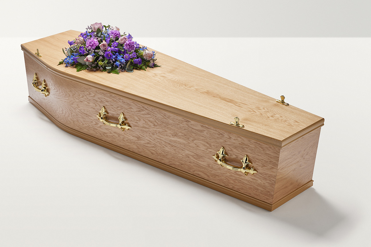 Zoomed out shot of purple flowers on top of coffin