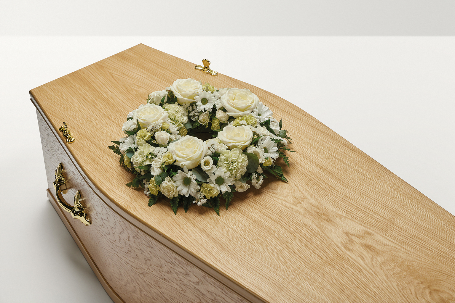 White wreath of flowers on top of coffin