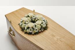 White wreath of flowers on top of coffin