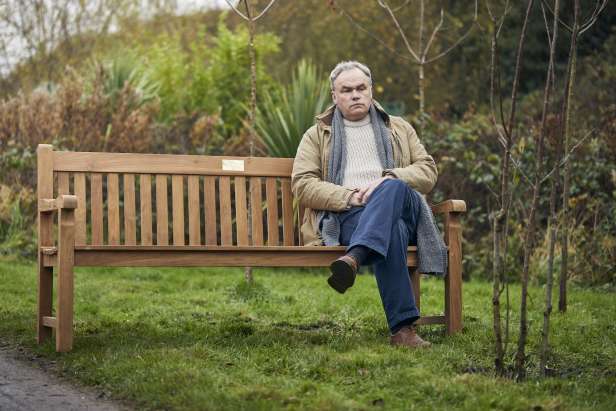 Man sat on a memorial bench