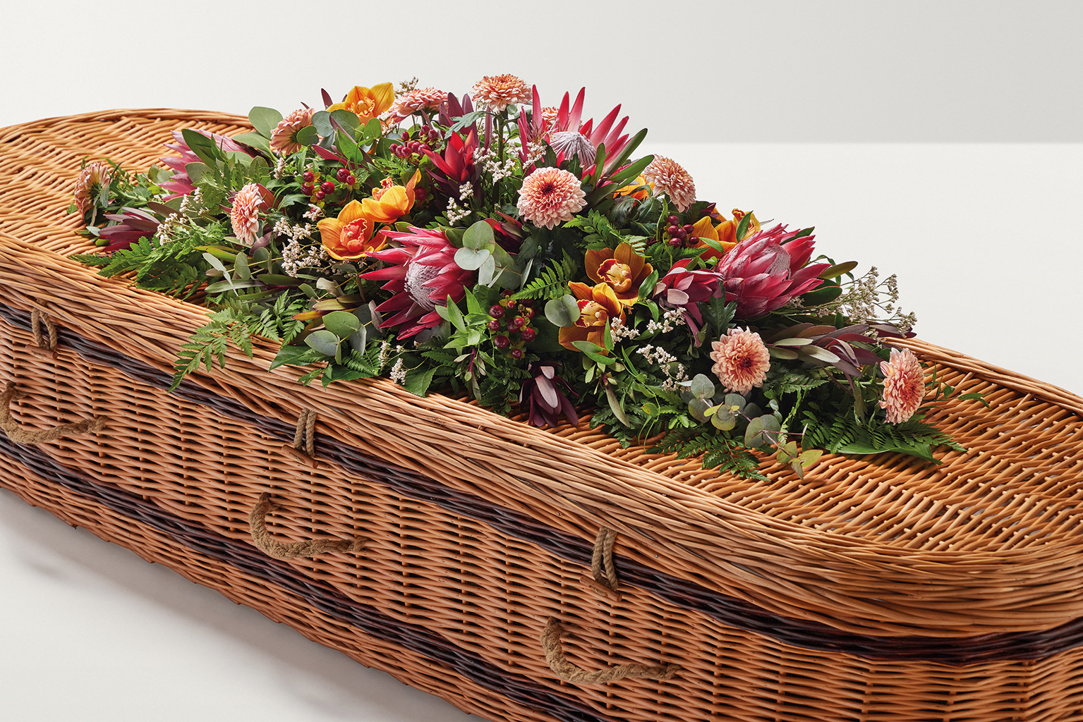 Peach coloured flower display on top of coffin