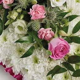 Zoomed in shot of pillow-shaped floral display in pink 
