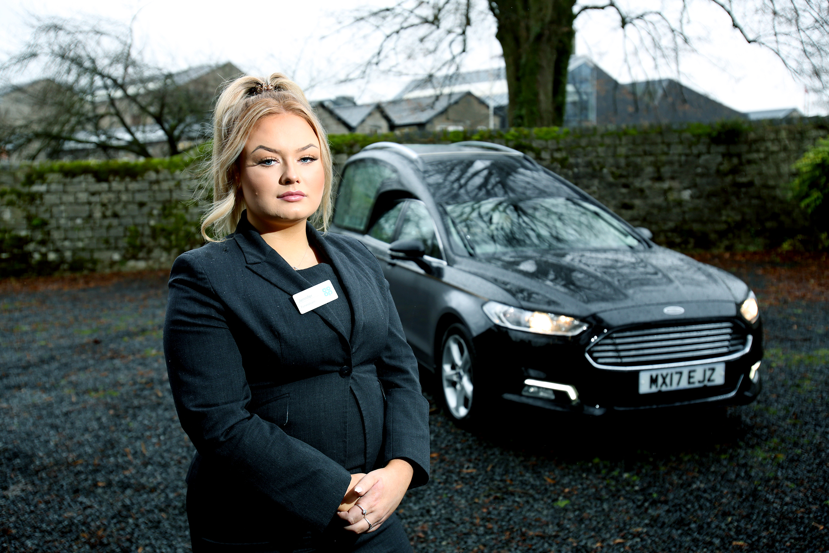 Jennifer 3000th apprentice stood in front of a hearse. 