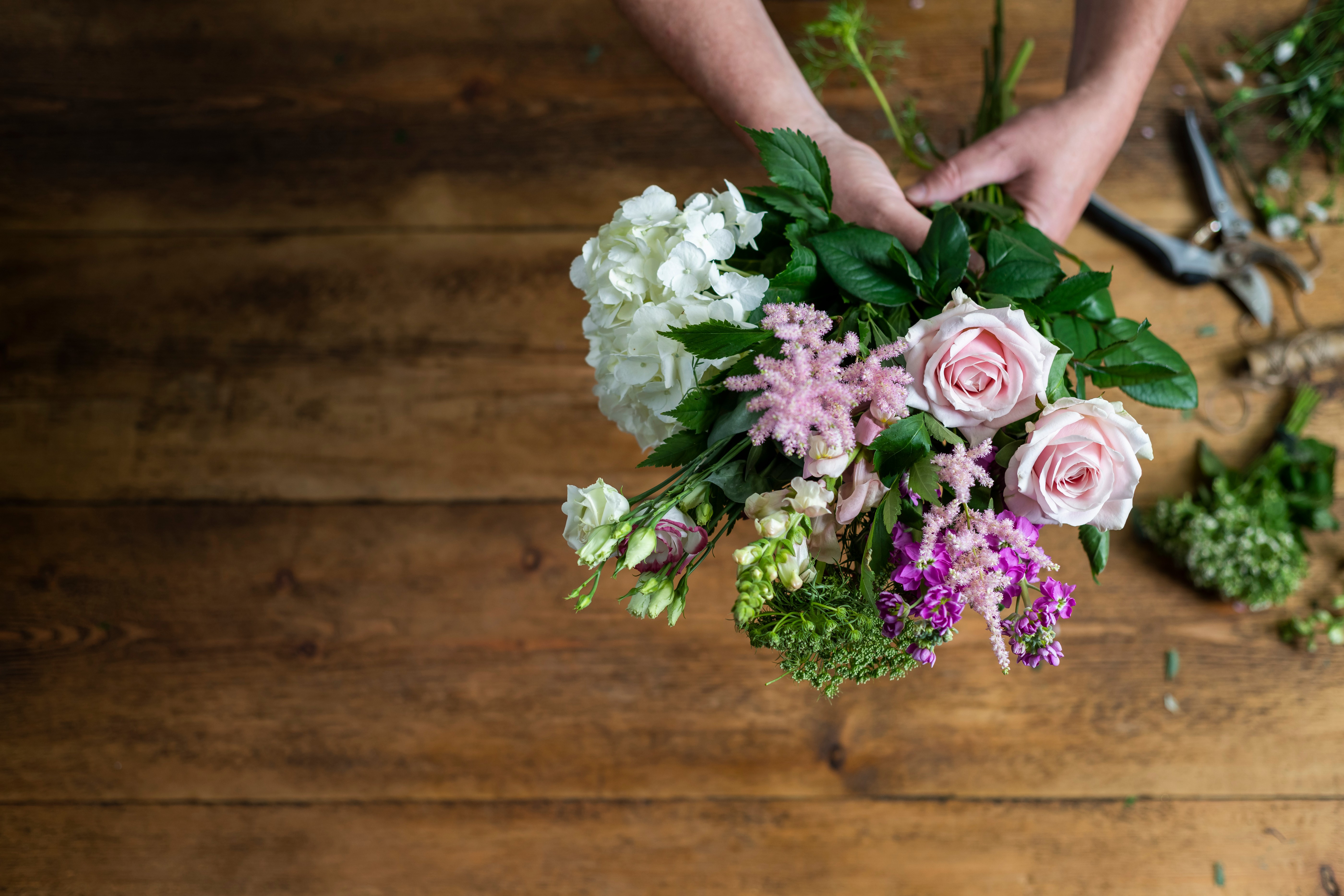 Hands creating a flower arrangement